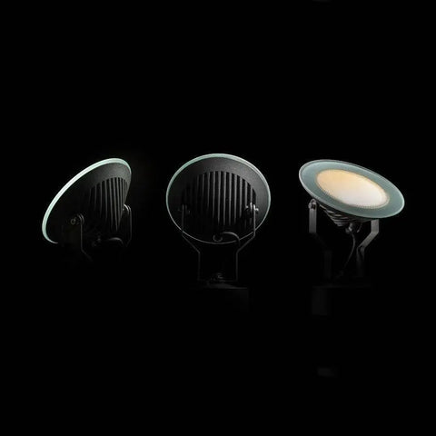 Kolme säädettävää FOX LED-ulkovalaisinta valaistuksessa – Kolme tummanharmaata FOX LED-heijastinvalaisinta, joissa kirkas lasikupu, valaistuna pimeässä, näyttää valaisimien säätömahdollisuudet ja kirkkaan valotehon ulkokäytössä.