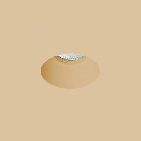 Upotettu kipsivalaisin beige taustalla, pyöreällä aukolla