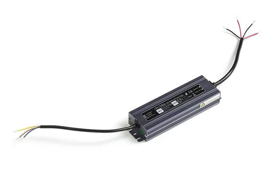 Musta LED-muuntaja johtimineen vaalealla taustalla