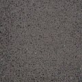 Lähikuva KANE I betoniseinävalaisimen tummasta graniittipinnasta, tyylikäs ja kestävä ulkovalaisin.